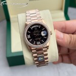 Sunday date display series women's watch with hematite-colored dial, diamond-set bezel, 36mm rose gold President-style bracelet.