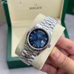 Sunday Calendar series women's watch with diamond-set gradient blue dial, diamond-set bezel, 36mm case, and silver President-style bracelet.