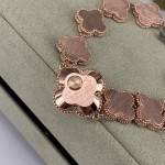 Van Cleef & Arpels watch with a rose gold dial featuring a pink mother-of-pearl clover motif.