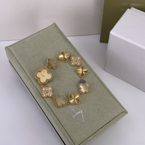 Van Cleef & Arpels watch with gold dial, mother-of-pearl, and diamond-set clover motif.