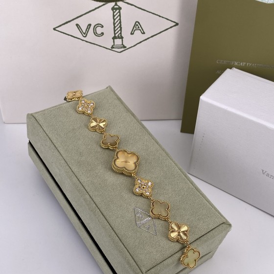 Van Cleef & Arpels watch with gold dial, mother-of-pearl, and diamond-set clover motif.