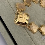 Van Cleef & Arpels watch with gold dial, mother-of-pearl, and diamond-set clover motif.