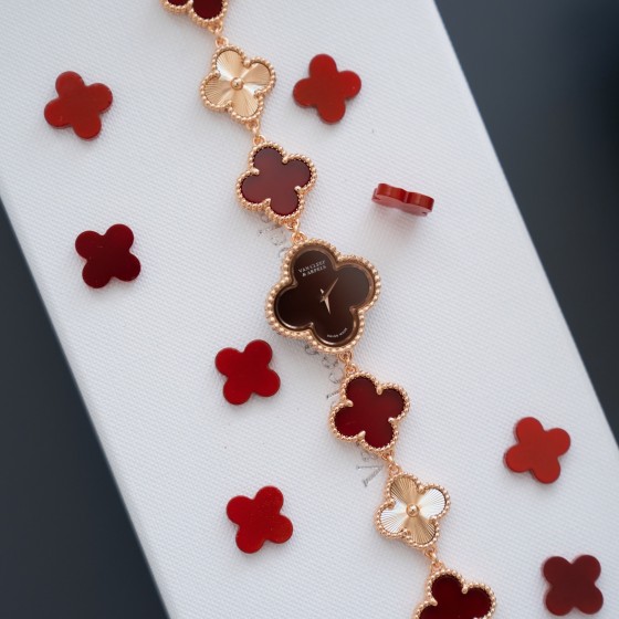 Van Cleef & Arpels watch with a brown dial and red mother-of-pearl clover motif.