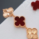Van Cleef & Arpels watch with a brown dial and red mother-of-pearl clover motif.