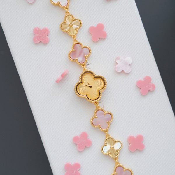 Van Cleef & Arpels watch with a gold dial featuring a pink mother-of-pearl clover motif.