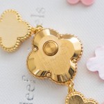 Van Cleef & Arpels watch with a gold dial featuring a pink mother-of-pearl clover motif.