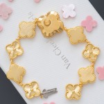 Van Cleef & Arpels watch with a gold dial featuring a pink mother-of-pearl clover motif.