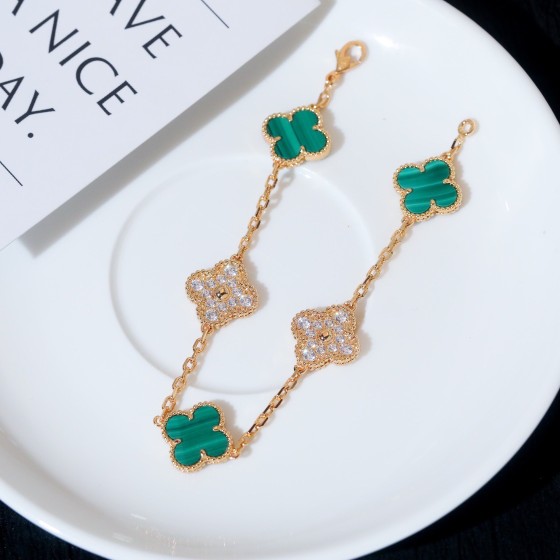 Four-leaf clover and peacock green enamel bracelet with interspersed rhinestones.