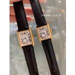 Cartier Tank watch, gold bezel, black leather strap.