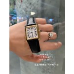 Cartier Tank watch, gold bezel, black leather strap.